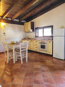 塔维亚诺Gallipoli lato sudChalet Pesco的厨房配有桌子和白色冰箱。