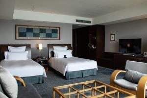 尾道市尾道贝拉维斯塔温泉码头酒店的酒店客房设有两张床和一台平面电视。