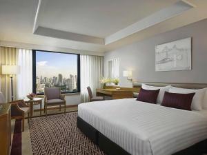 曼谷Grand Mercure Bangkok Atrium的酒店客房设有一张床和一个大窗户