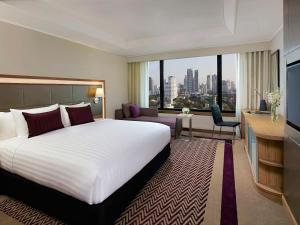 曼谷Grand Mercure Bangkok Atrium的一间酒店客房,设有一张大床和一个大窗户