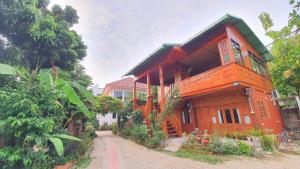 南邦Kanecha's Home Lampang的街道中央的大木房子