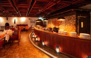 TsavoTaita Hills Safari Resort & Spa的餐厅设有酒吧,柜台上摆放着盘子
