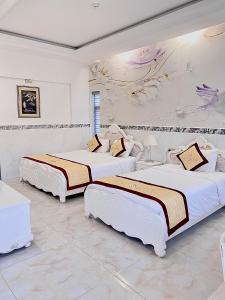 富国富国岛歌迪瓦酒店的白色墙壁客房的两张床
