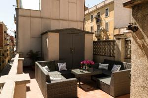 巴塞罗那Barcelona Beach Home的阳台设有带藤椅和桌子的庭院