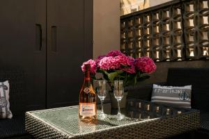 巴塞罗那Barcelona Beach Home的鲜花桌子上的一瓶葡萄酒和玻璃杯
