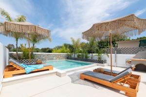 法里拉基Aqua Villa Faliraki的别墅 - 带带2把椅子和遮阳伞的游泳池