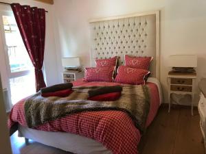 BolsenheimLes Authentics - Le Domaine d'Autrefois & Spa的一间卧室配有一张带红色枕头的大床