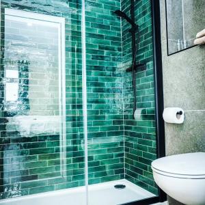 基拉尼法尔特酒店的绿色瓷砖浴室设有淋浴和卫生间