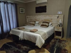 KraaifonteinVilla Mariss Guesthouse的一间卧室配有一张大床和木制床头板
