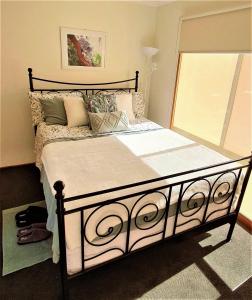 切尔滕纳姆Beach Garden Getaway的一间卧室配有一张带枕头的大床