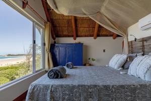 托弗海滩Pura Vida Tofo Beach Houses的一间卧室配有一张床,享有海滩美景