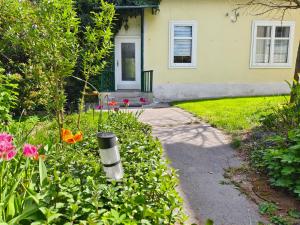 LangenzersdorfCharmantes Haus mit Terrasse und großem Garten的一座带鲜花和走道的花园的房子