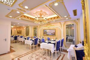 伊斯坦布尔Golden Marmara Hotel的用餐室配有白色的桌子和蓝色的椅子
