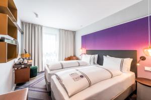 海德堡Premier Inn Heidelberg City Bahnstadt的紫色墙壁旅馆客房的两张床