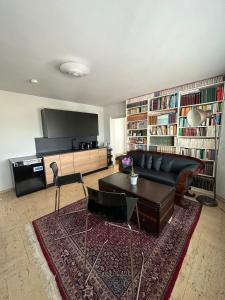 美因河畔法兰克福Penthouse Frankfurt的客厅配有黑色沙发和桌子