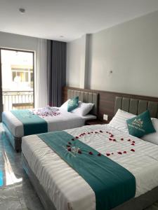 下龙湾Tuần Châu HQT的酒店客房设有两张带玫瑰花的床。