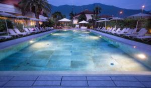 阿科城市宫殿酒店的游泳池在晚上提供椅子和遮阳伞