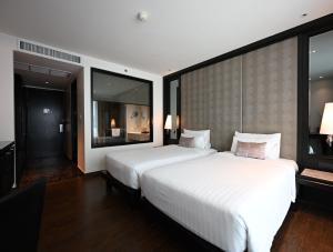 曼谷曼谷素坤逸 15 号瑞享酒店的一间大型卧室,配有两张床和大窗户