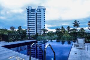 康提Hotel Ganthera Kandy的一座游泳池,其背后是一座高大的建筑