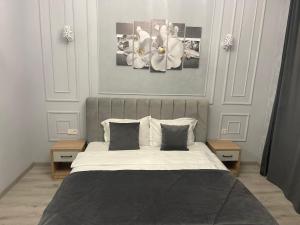 阿拉木图Aura Almaty的卧室配有一张墙上白色鲜花的床