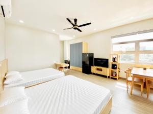 岘港Moc Son Apartment - Attractive price for week and month stay的一间酒店客房,设有两张床和一间餐厅