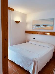 卡拉古诺内波普酒店的卧室配有白色的床和墙上的绘画作品