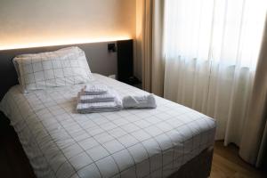 克罗诺奥赛里VILLA MANZONI的一张带白色床单和毛巾的床