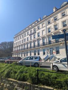 斯卡伯勒Bike & Boot Inns Scarborough - Leisure Hotels for Now的一座白色的大建筑,前面有汽车停放