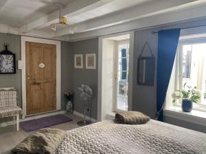 克拉格勒Monas sommerresidens midt i hjertet av Kragerø的一间卧室配有一张床,另一扇门配有风扇