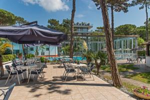 利尼亚诺萨比亚多罗麦瑞迪阿纳斯酒店的一个带桌椅和遮阳伞的庭院