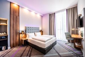 海德堡Premier Inn Heidelberg City Centre的配有一张床和一张书桌的酒店客房