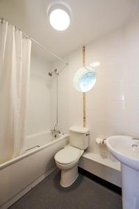 RuffordRed Lion, Wigan by Marston's Inns的白色的浴室设有卫生间和水槽。