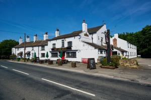 RuffordRed Lion, Wigan by Marston's Inns的街道边的白色大建筑