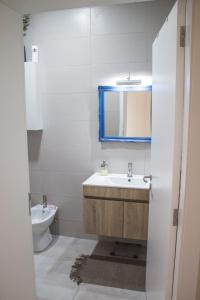 英雄港Casa da Memória的一间带水槽、镜子和卫生间的浴室