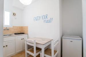 帕罗奇亚Livadia Seaside Studios 14的白色的厨房配有桌子和水槽