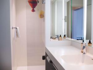 洛里昂洛里昂中心美居酒店的白色的浴室设有水槽和镜子