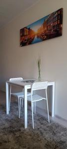 帕兰加Apartamentai PAlanga的客房内的一张白色桌子和两把椅子