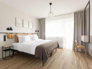 塔林Oru Hub Hotel Tallinn - Handwritten Collection的一间卧室设有一张床和一个大窗户