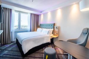 科隆Premier Inn Köln City Süd的配有一张床、一张书桌和一扇窗户的酒店客房