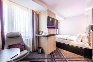 科隆Premier Inn Köln City Süd的酒店的客房 - 带一张床、椅子和电视