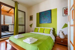 加利波利Mini Appartamento verde的一间卧室配有绿床和毛巾
