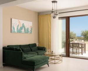 马鲁拉斯Mela Luxury Apartments的客厅配有绿色沙发和玻璃桌