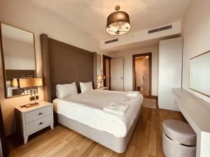 伊斯坦布尔Maslak Aparts的卧室配有一张白色大床和镜子