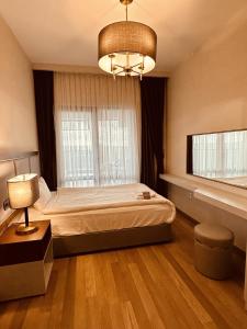 伊斯坦布尔Maslak Aparts的一间卧室配有一张床和一个吊灯