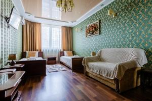 基辅Poznyakoff Aparthotel的客厅配有绿色壁纸、沙发和椅子
