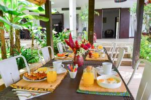 阿比让Gaïa's Garden B&B Abidjan的一张桌子,上面放着早餐食品和橙汁