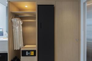 釜山Hotel Marine view的衣柜,带黑色门和白色长袍