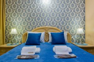 基辅Poznyakoff Aparthotel的一间卧室配有蓝色的床和毛巾
