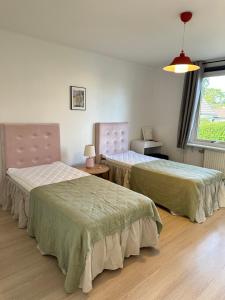 卡尔马Mysiga lägenheter i Kalmar centrum的客房设有两张床和窗户。