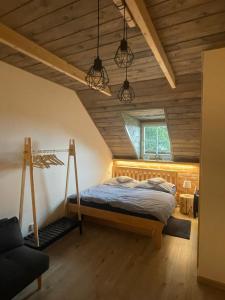 斯塔雷梅斯托Chaloupka Kunčice的一间带一张床的卧室,位于带木制天花板的房间内